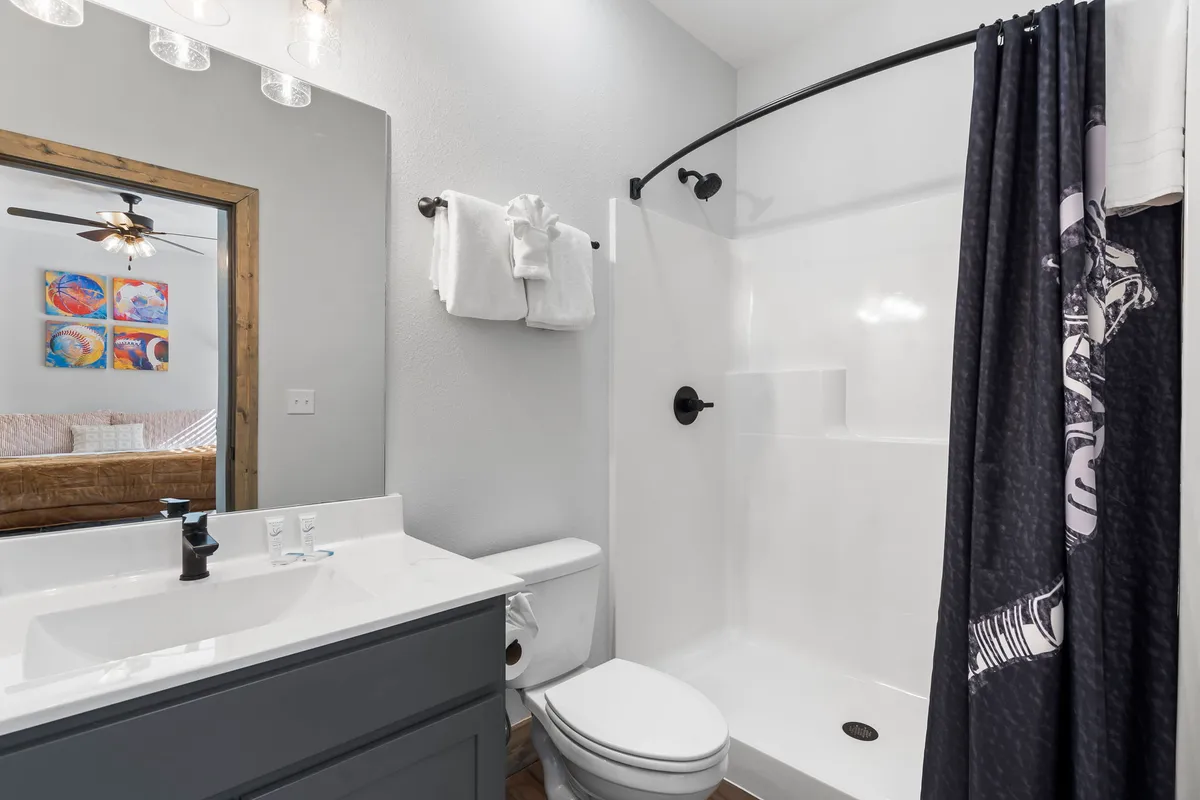 A bright, inviting ensuite bathroom with a stylish vanity, sink, shower area, and decorative artwork. The space feels fresh and private, supporting the idea of ensuite bathrooms for each bedroom.